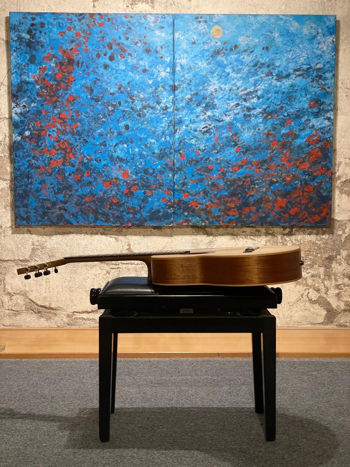 Classical guitar beneath a blue Mediterranean painting
